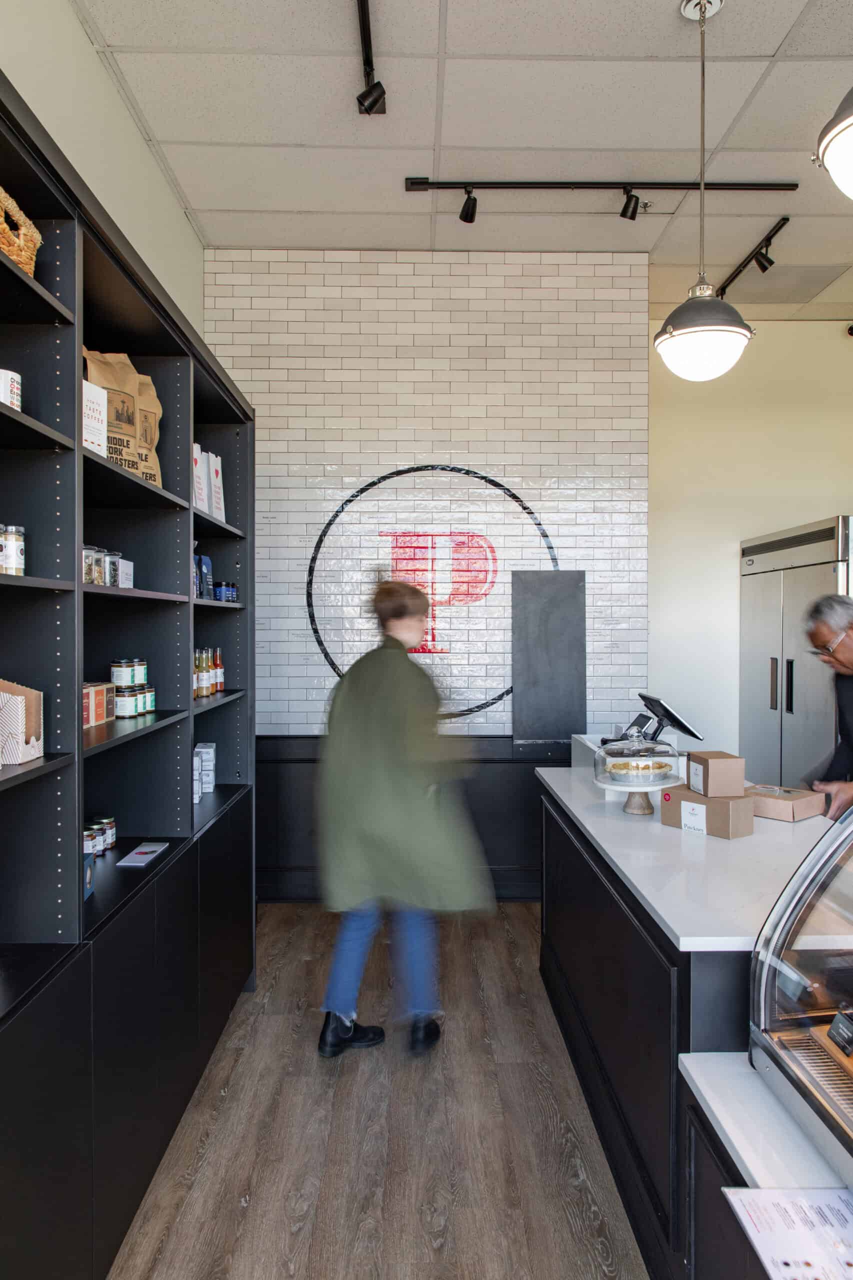 Modern interior of Office of Ordinary Architecture with retail shelves and reception desk.