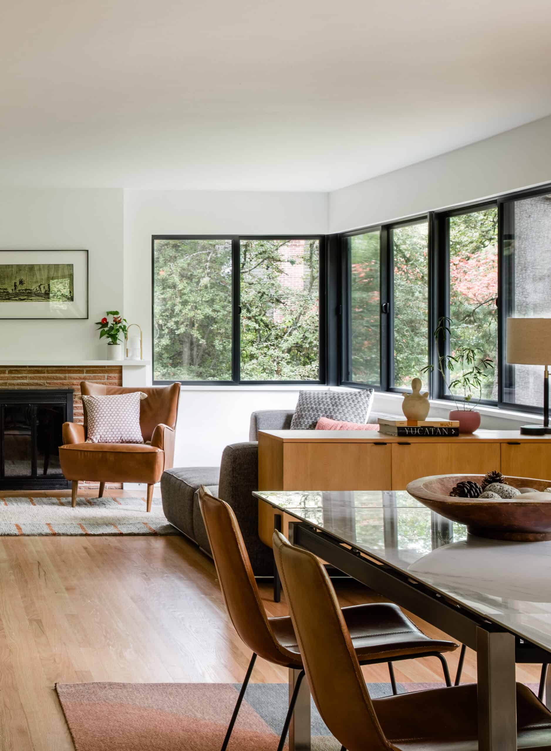Bright living room with large windows, wooden furniture, and contemporary decor.