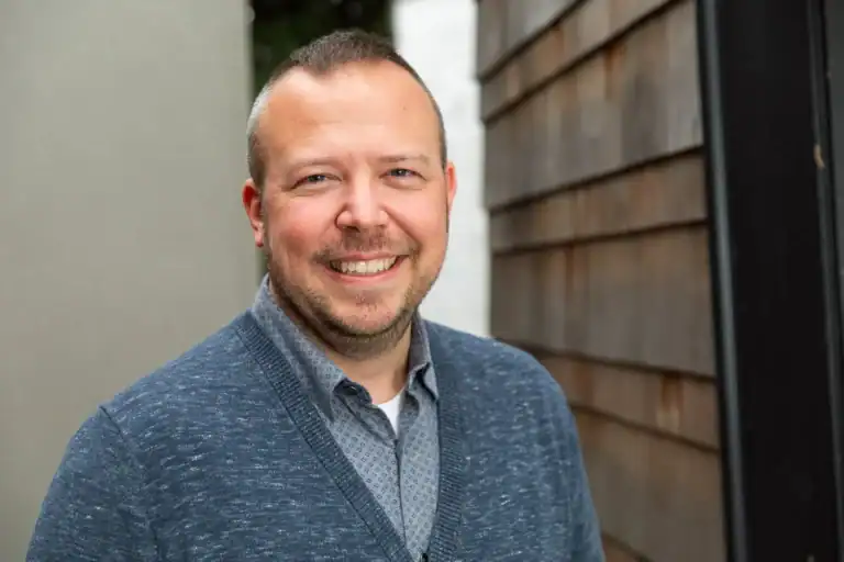 Portrait of a smiling man in casual attire at Office of Ordinary Architecture.