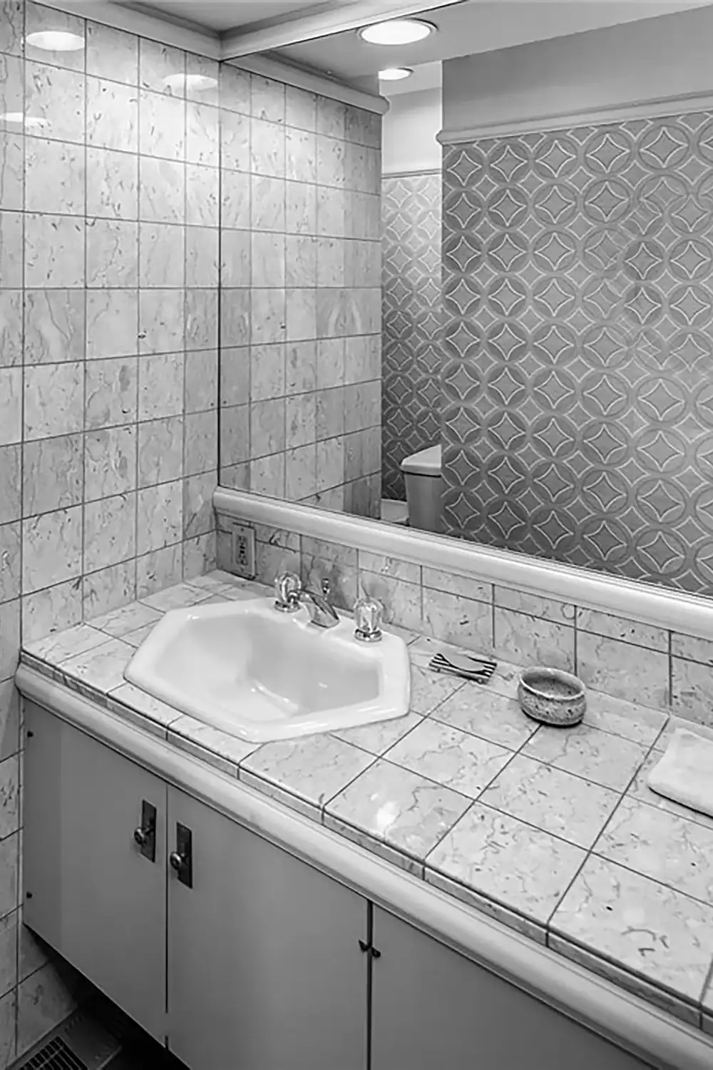 Vintage bathroom with tiled walls and a marble countertop sink.