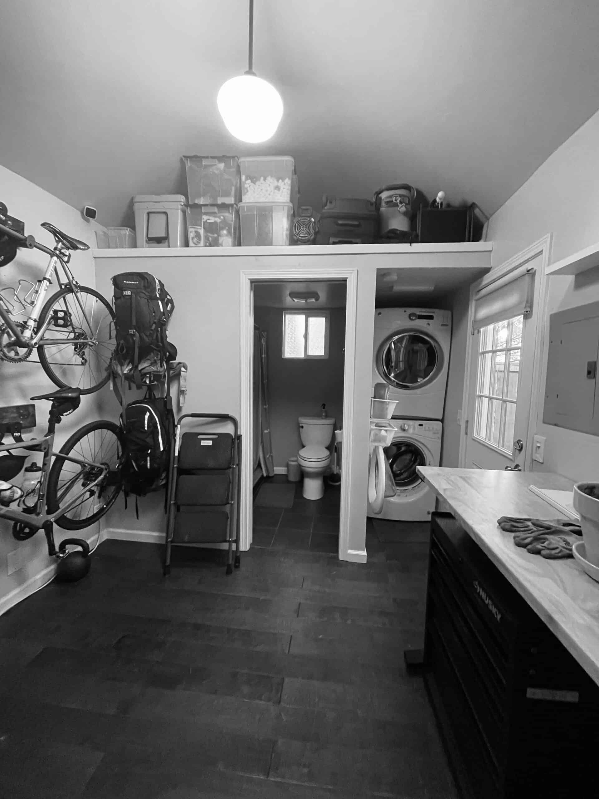 Compact laundry and storage room with bicycles and washing machine in Seattle Backyard Studio.