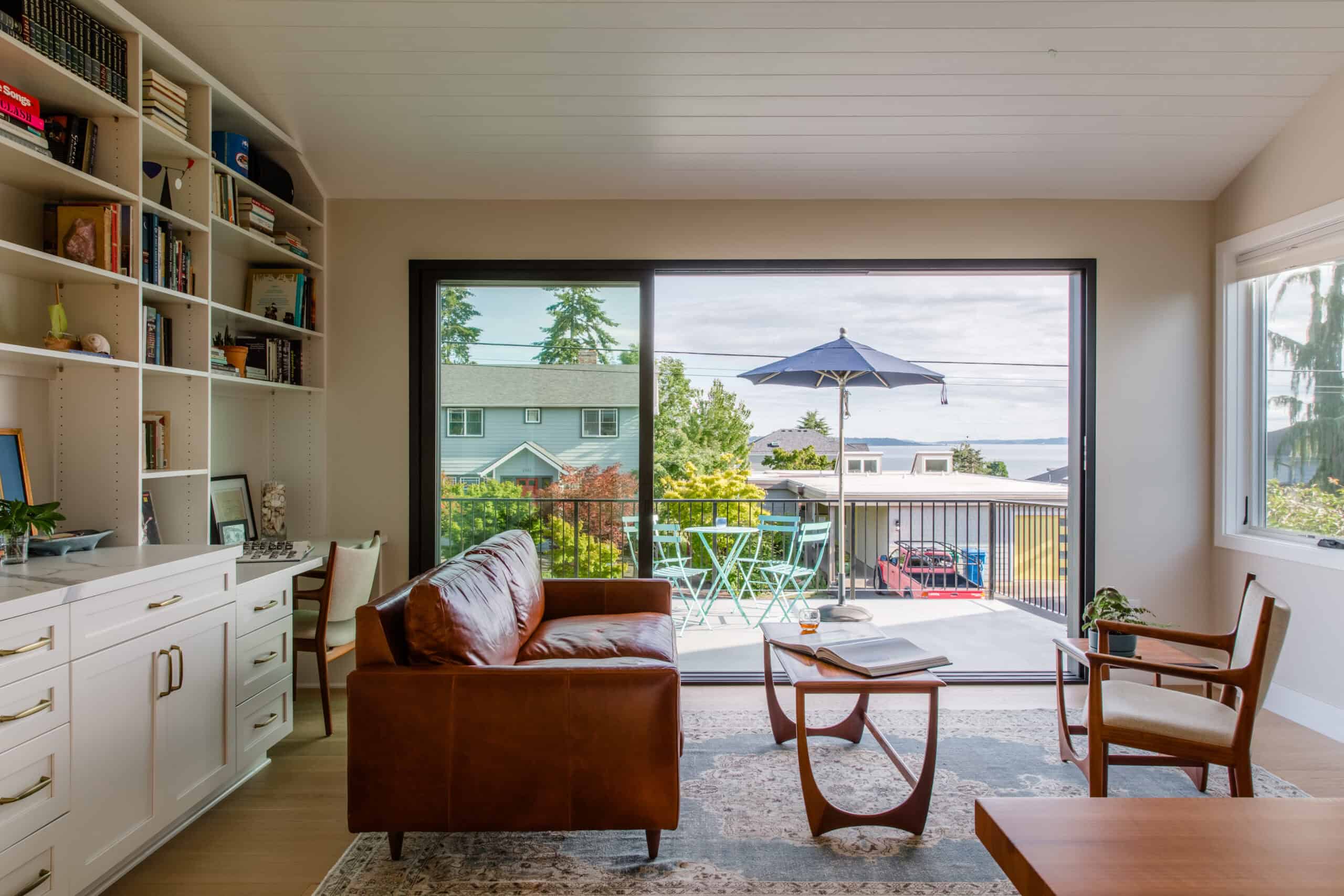 Bright living room with large sliding glass door to balcony and water view.