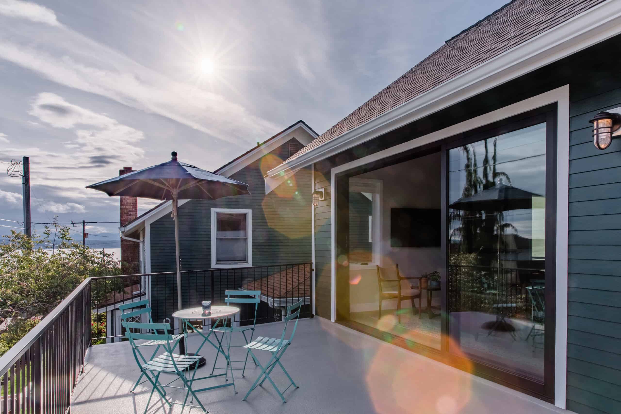 Modern outdoor patio with seating and umbrella at Richmond Beach ADU.