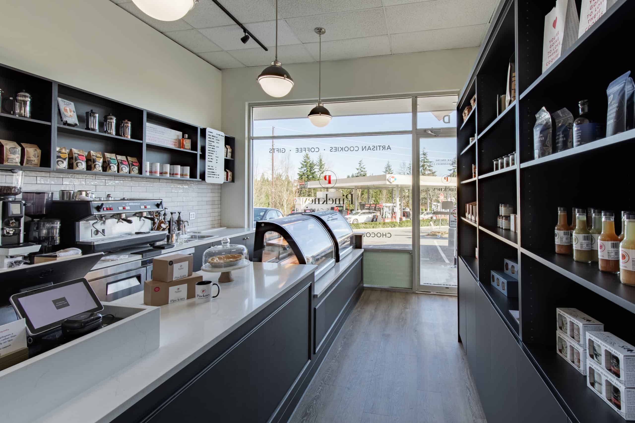 Modern retail space with shelves of products and a service counter.