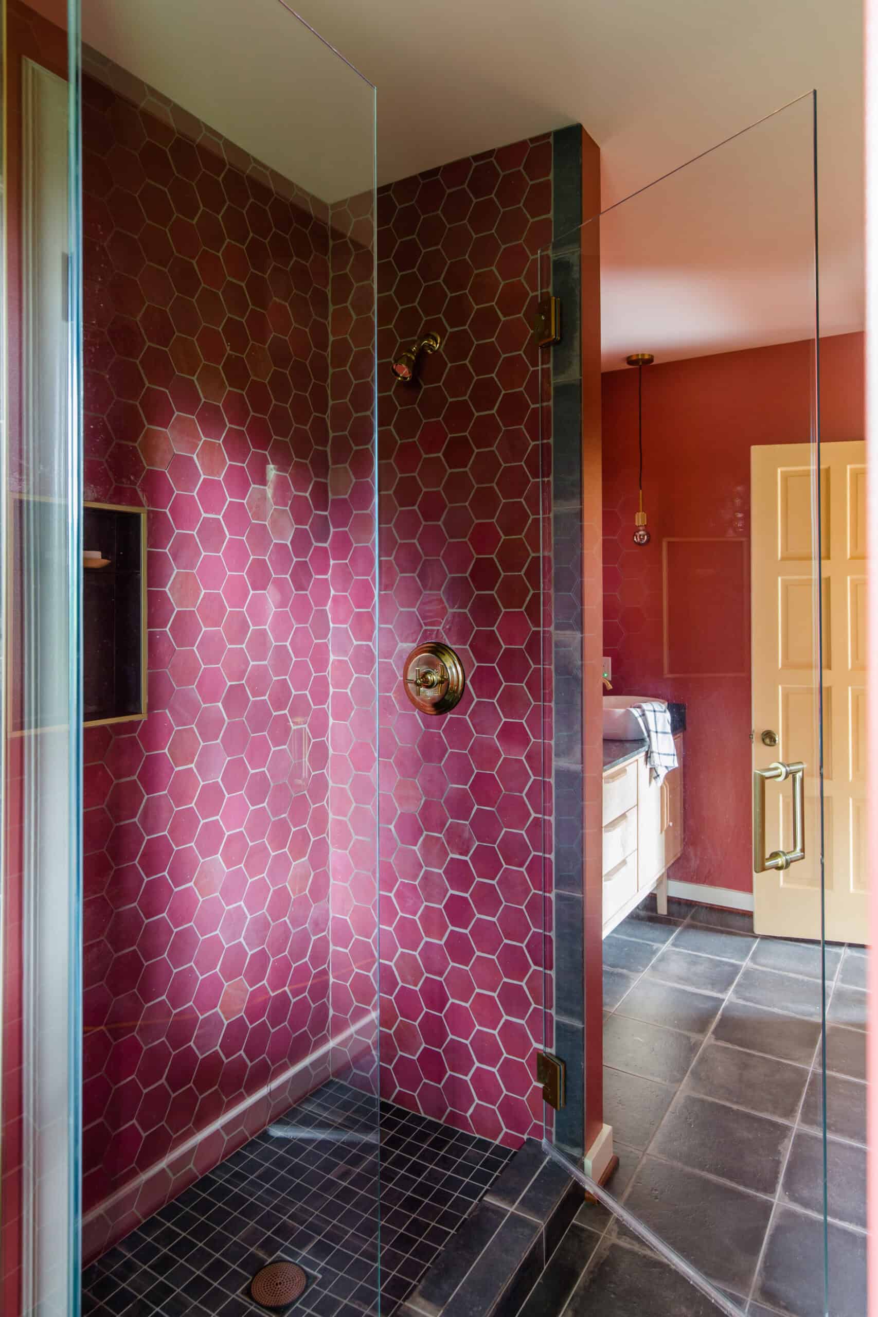 Bathroom shower with pink hex tile walls and glass enclosure.