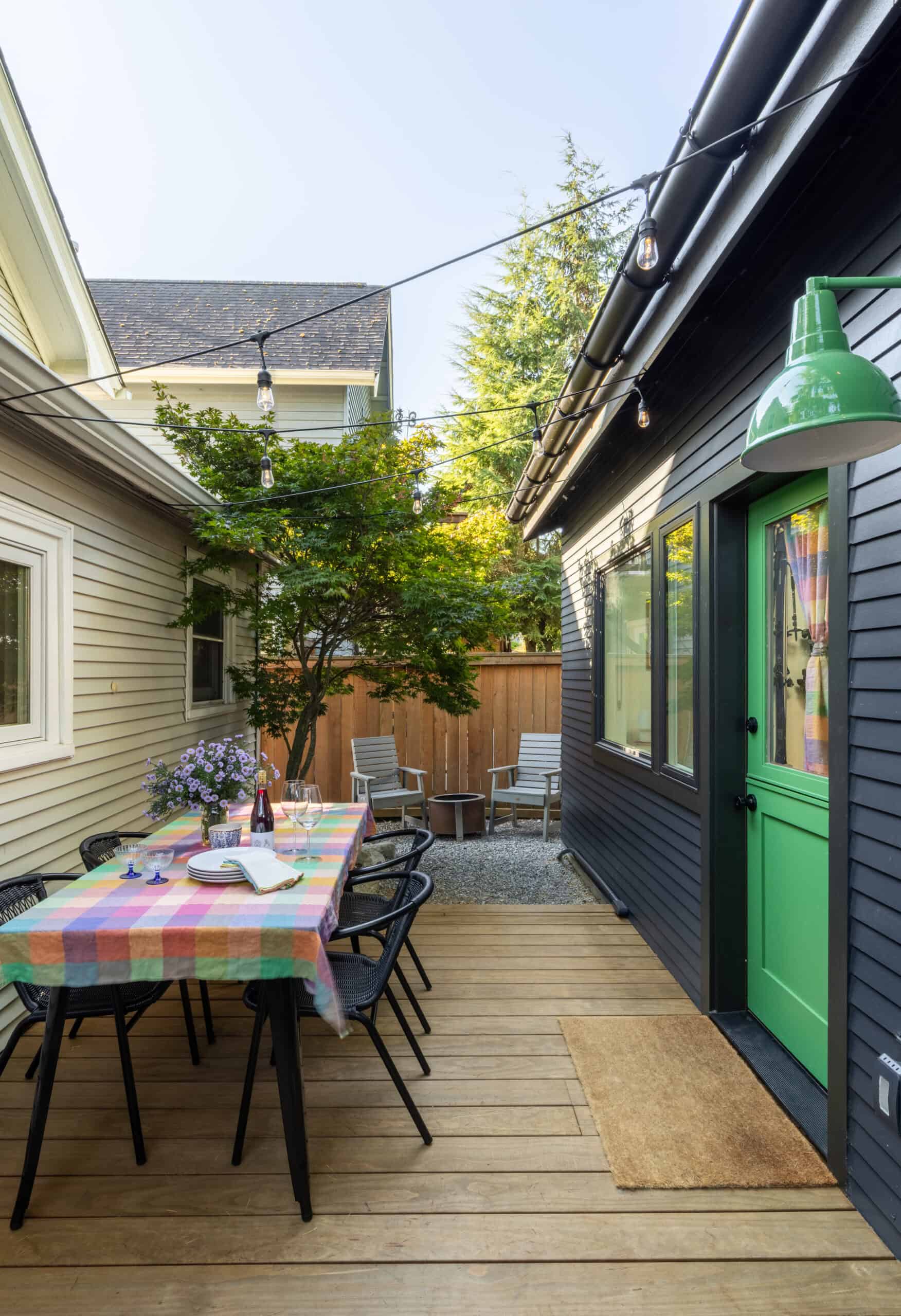 Cozy backyard patio with dining area and string lights under a clear sky.