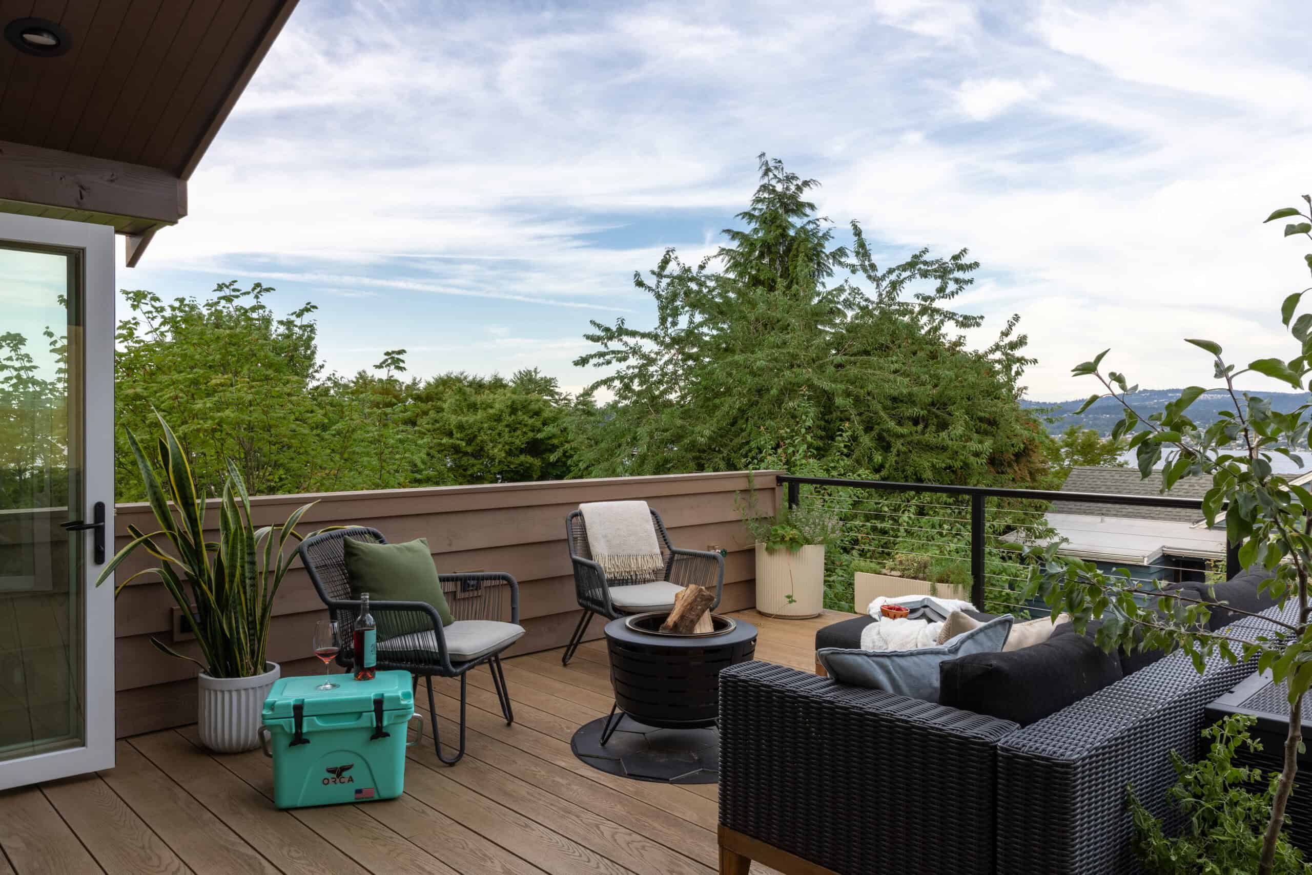 Outdoor balcony with seating and greenery, modern architecture design.
