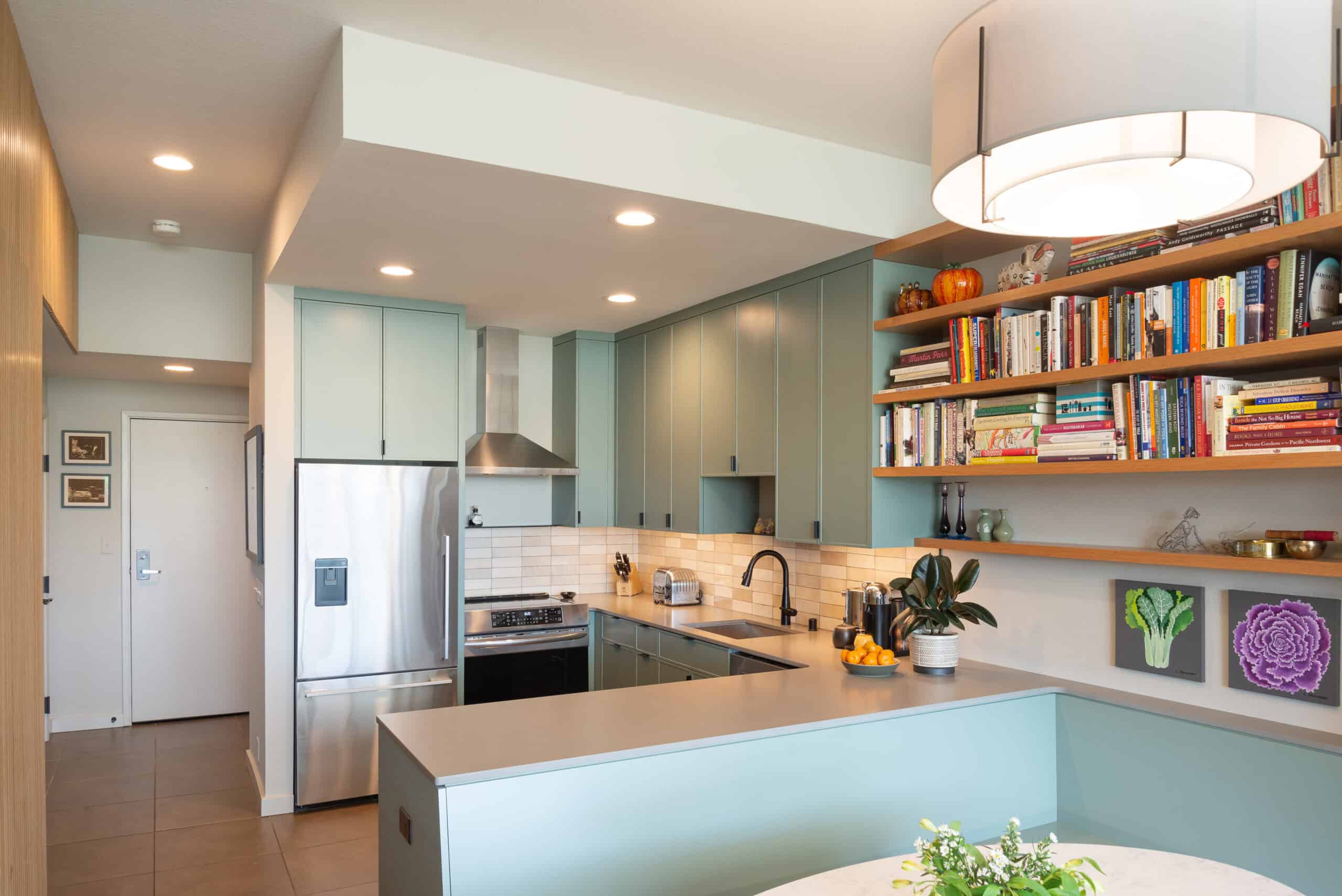 Modern condo kitchen with light blue cabinets and open shelving.