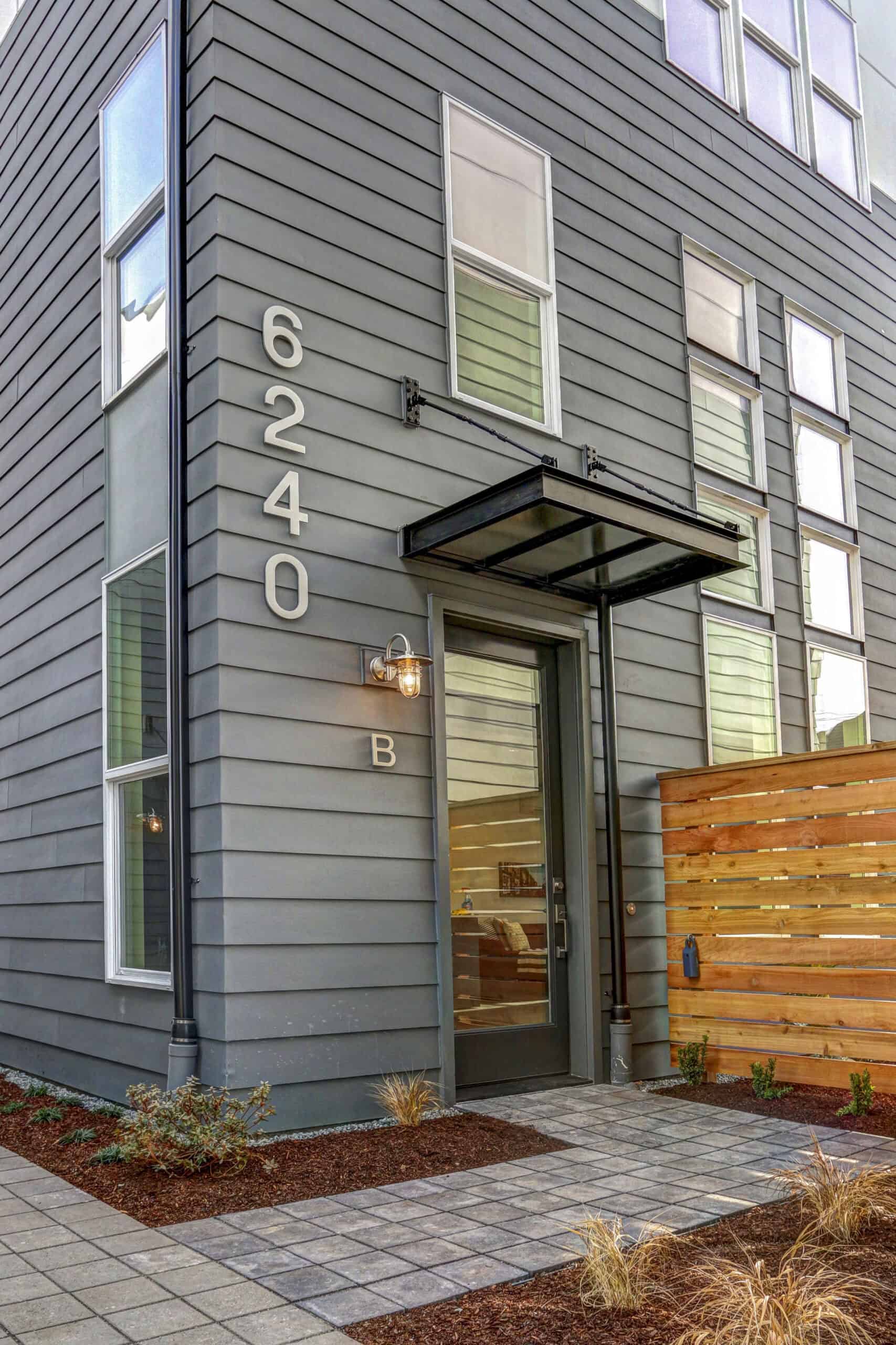 Contemporary apartment building with gray siding and large windows.