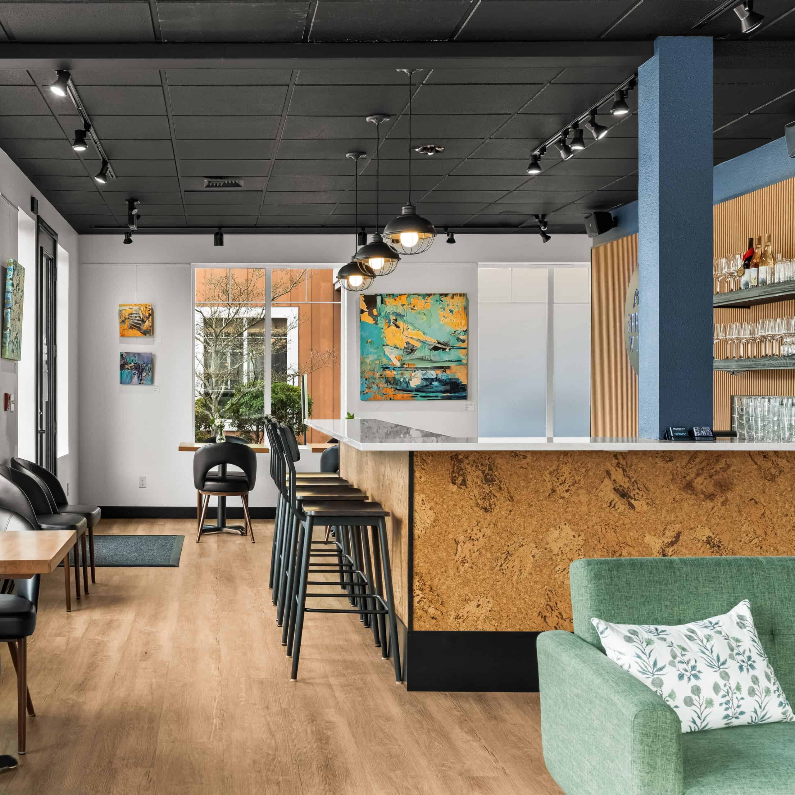 Modern interior of Office of Ordinary Architecture with bar seating and artwork.