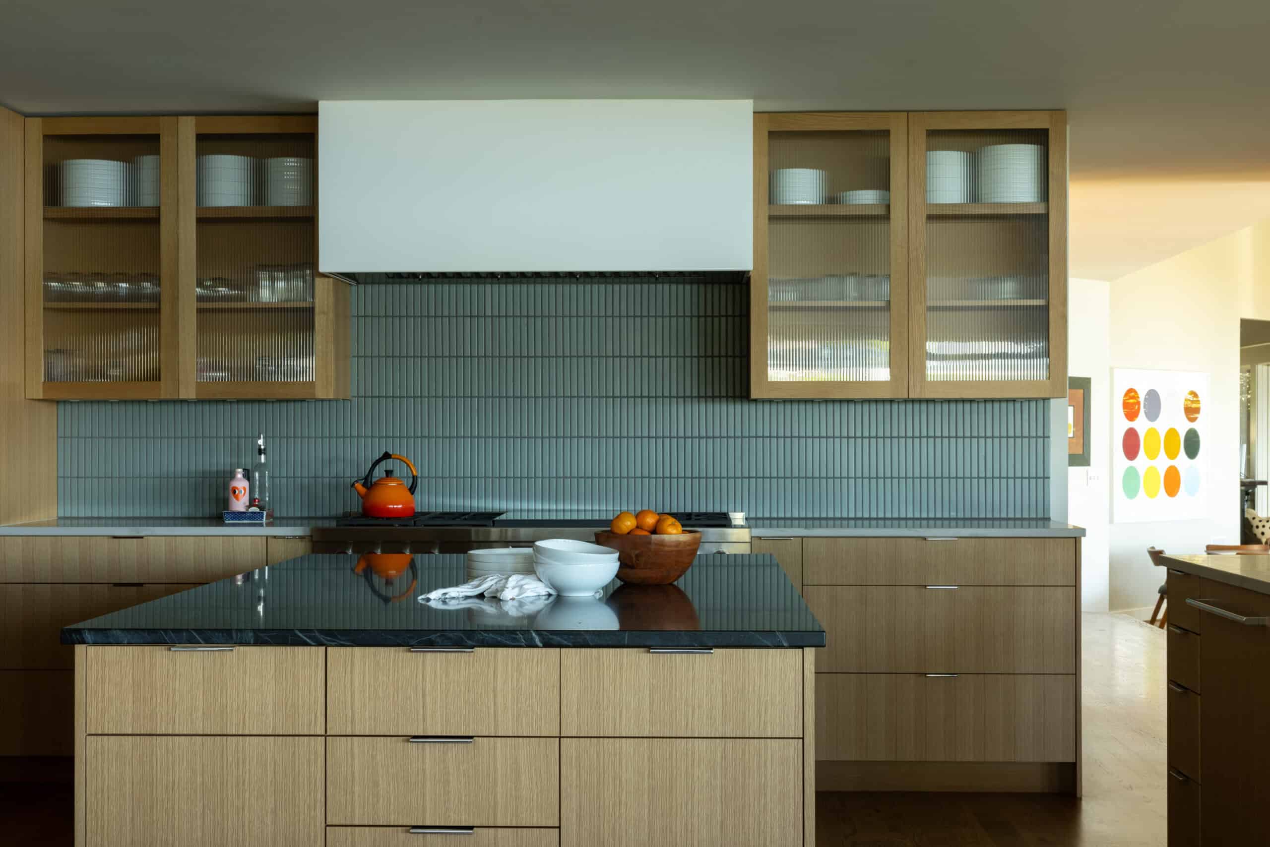 Contemporary kitchen with wooden cabinets and blue tile backsplash.